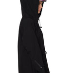 Profile view of hooded black pullover with helmet and ski goggles, highlighting ergonomic silhouette.