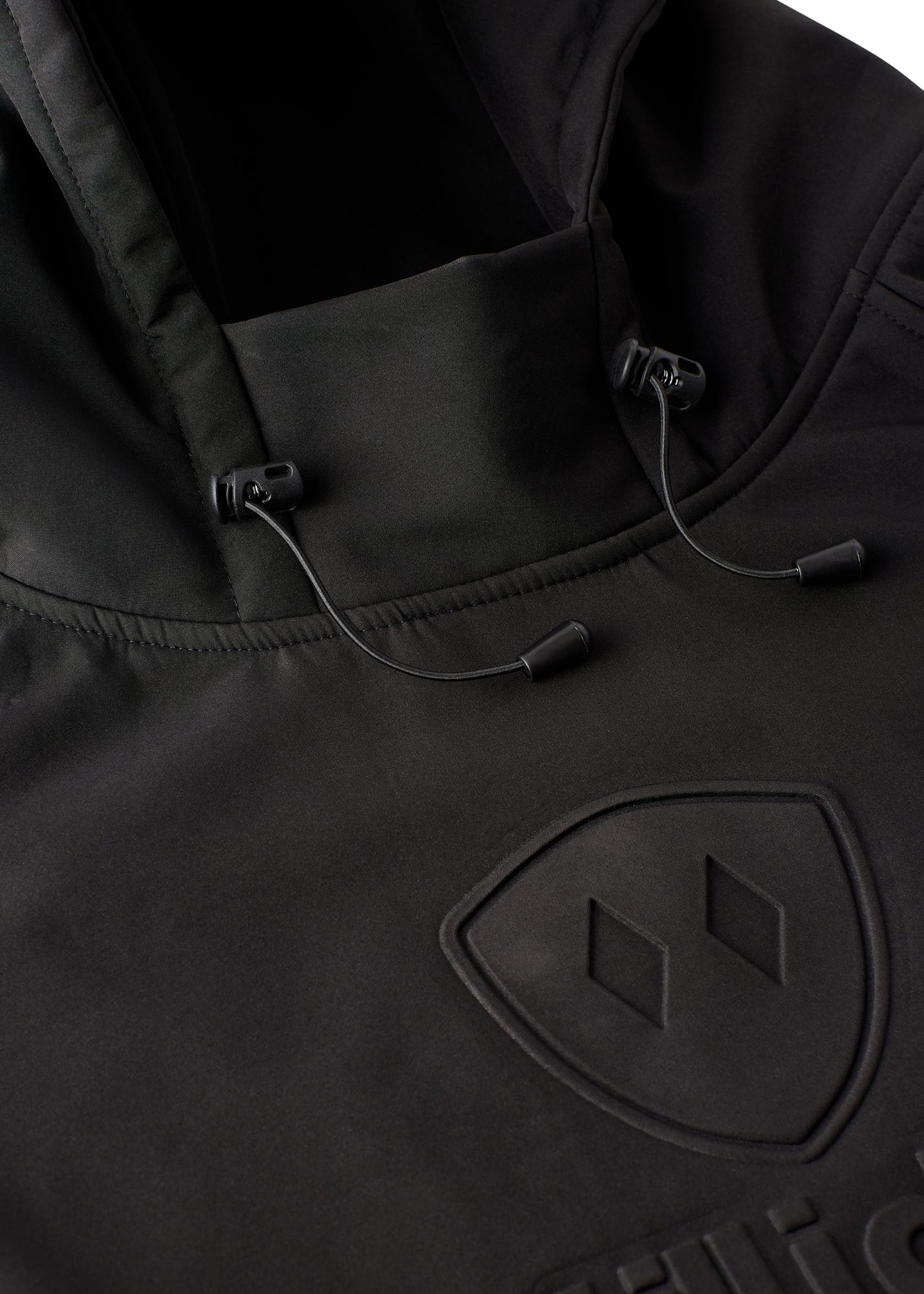 Close-up of helmet-compatible hood and drawcords on black performance pullover