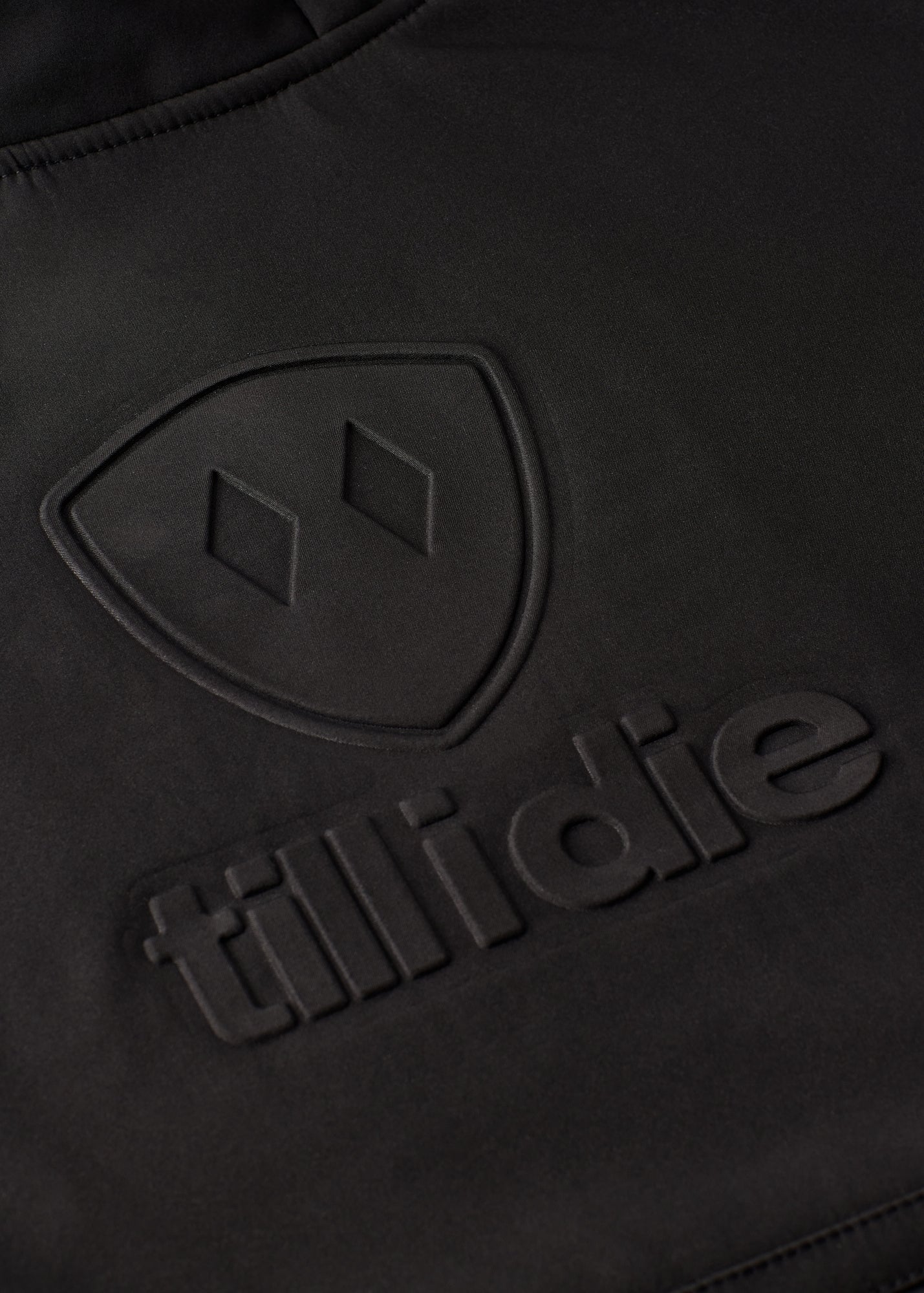Close-up of embossed double diamond shield and Till I Die logo on chest