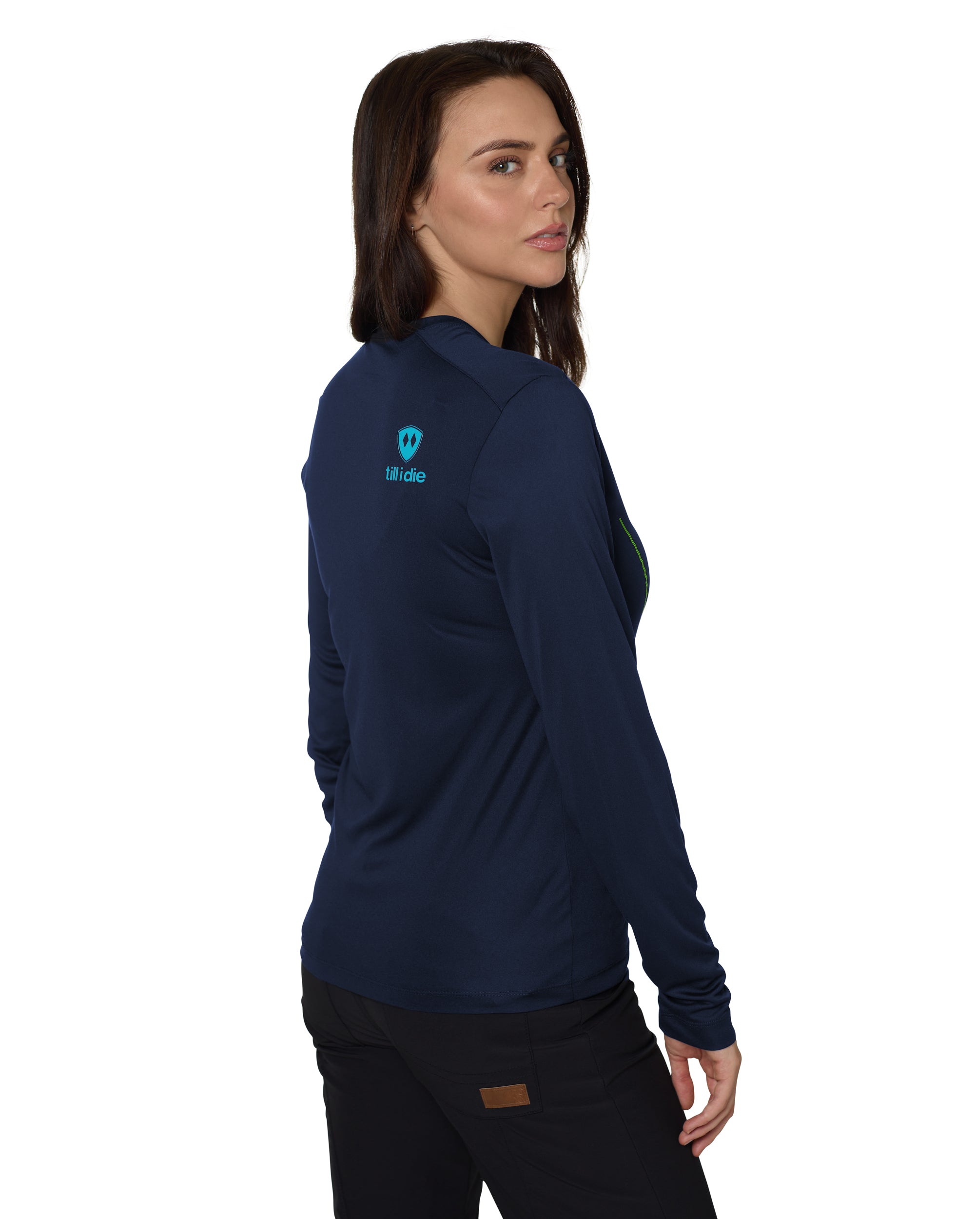 Back of a female model wearing the Chairlift performance long sleeve in Navy. A bright blue till i die logo is shown on the models top right shoulder.