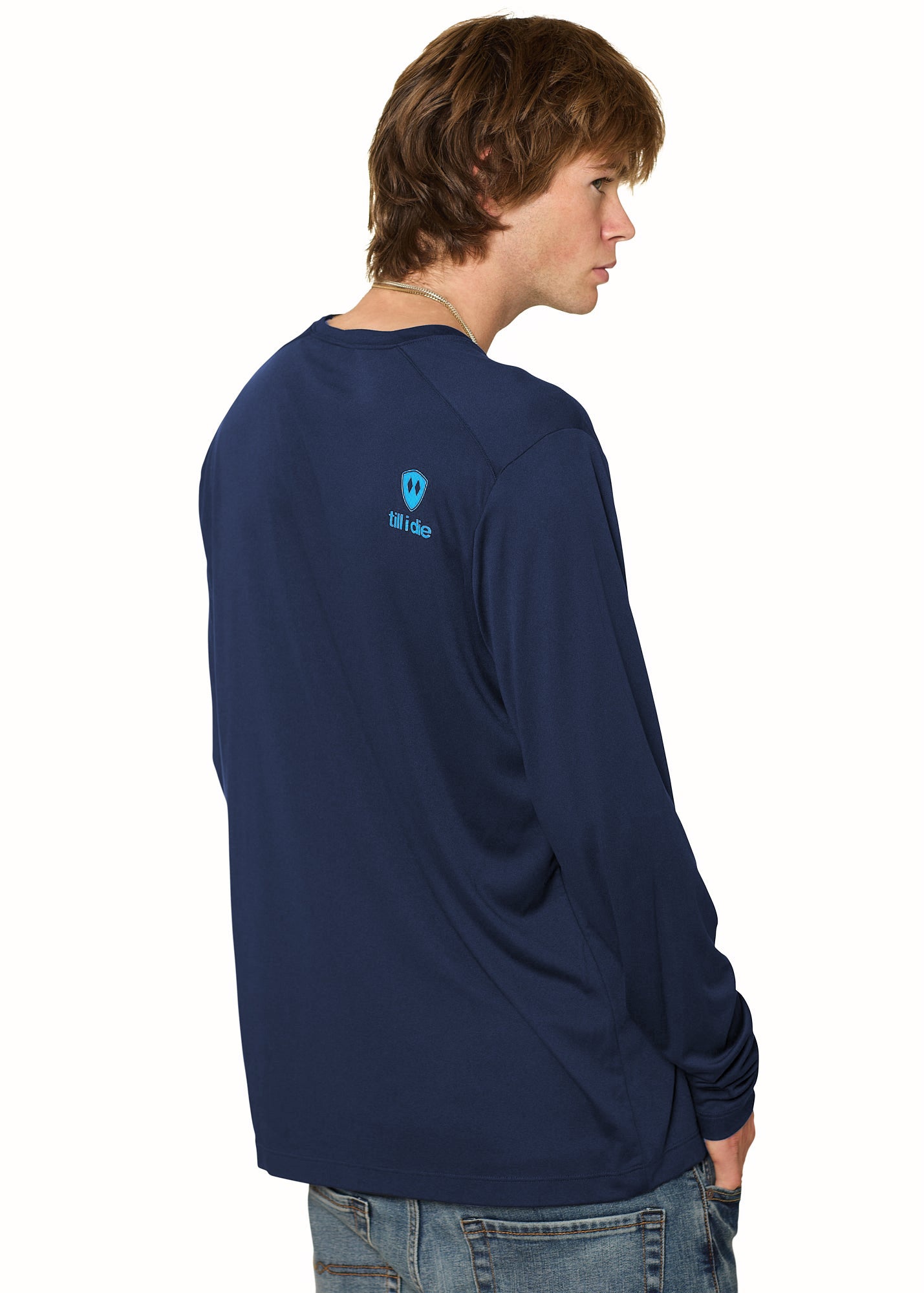 Back of a male model wearing the Chairlift performance long sleeve in Navy. A bright blue till i die logo is shown on the models top right shoulder.