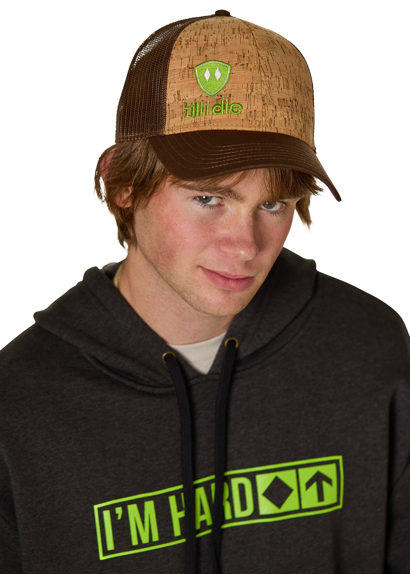male model wearing a brown cork trucker hat with a lime green till i die embroidered logo