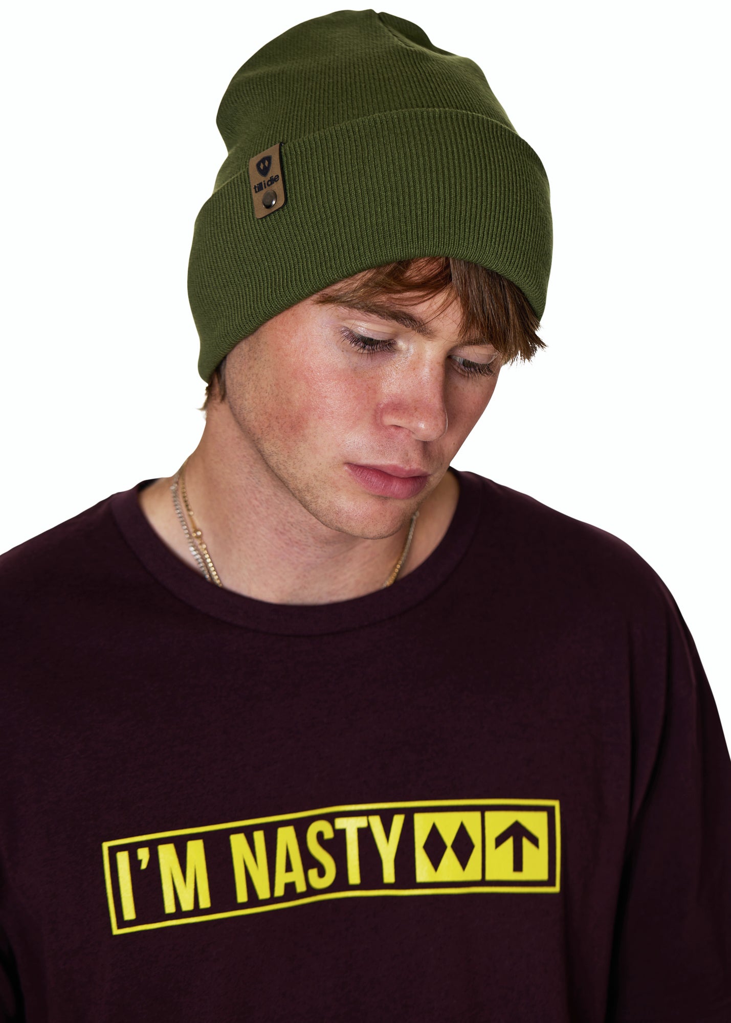 Male Model wearing a military green beanie and a oxblood shirt with 'I'M NASTY' text in bright yellow on a white background