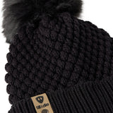 Close-up flat lay of the Diamond Knit Pom Beanie showing the textured diamond knit pattern, faux fur pom, and logo leather tab.