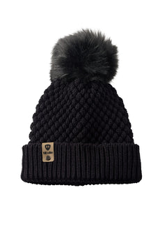 Product flat lay of the Diamond Knit Pom Beanie in black, displaying the ribbed cuff, diamond knit design, and leather logo tab with faux fur pom.