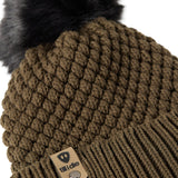 Close-up flat lay of the Diamond Knit Pom Beanie showing the textured diamond knit pattern, faux fur pom, and logo leather tab.