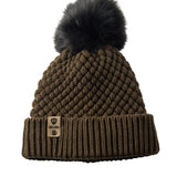 Product flat lay of the Diamond Knit Pom Beanie in military olive, displaying the ribbed cuff, diamond knit design, and leather logo tab with faux fur pom.