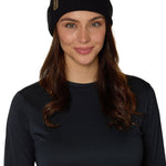 Female model wearing the Till I Die Leather Tab Knit Beanie in black, showcasing the cozy fit and branded leather detail on the cuff