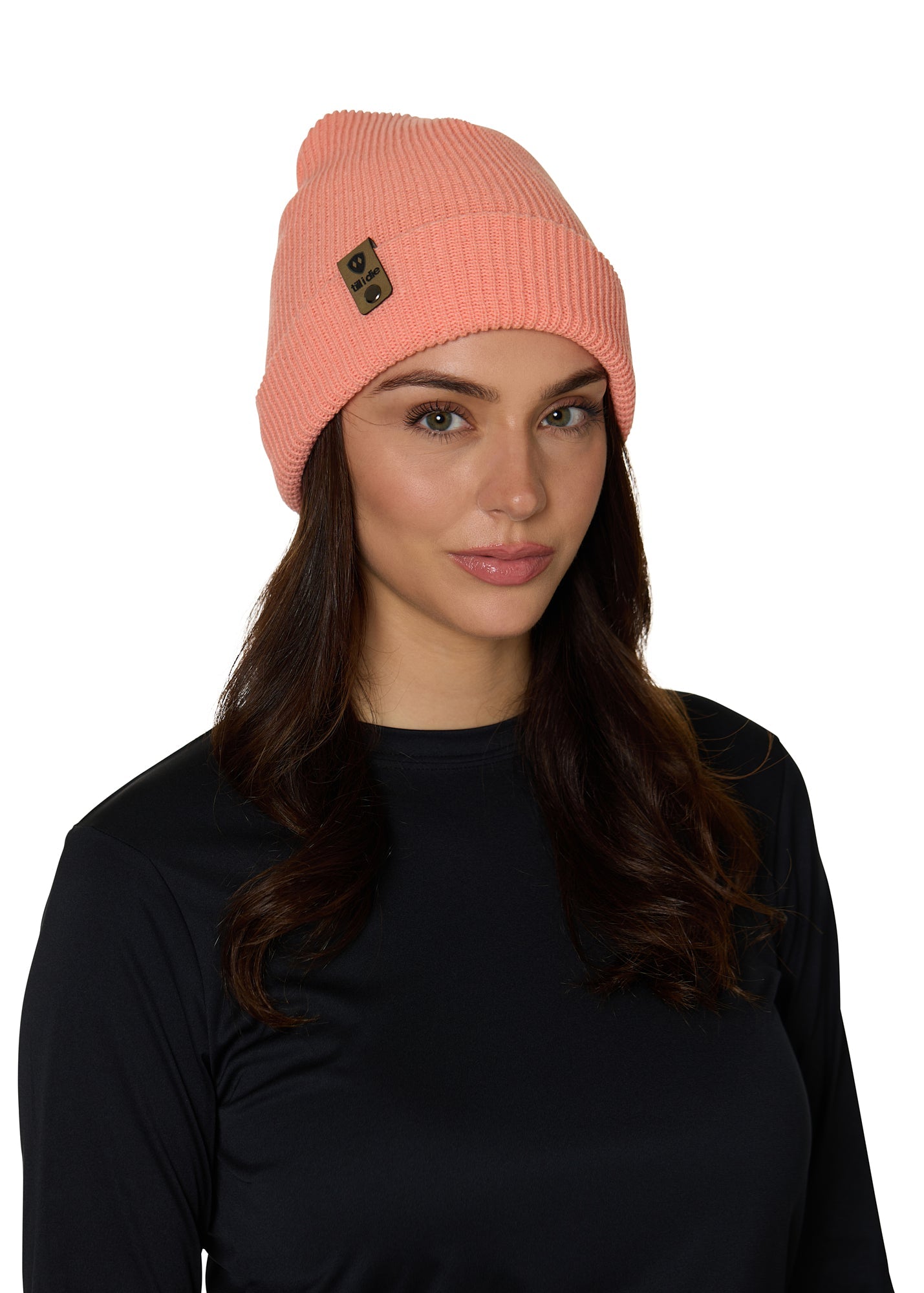 Female model wearing the Till I Die Leather Tab Knit Beanie in coral, showcasing the cozy fit and branded leather detail on the cuff