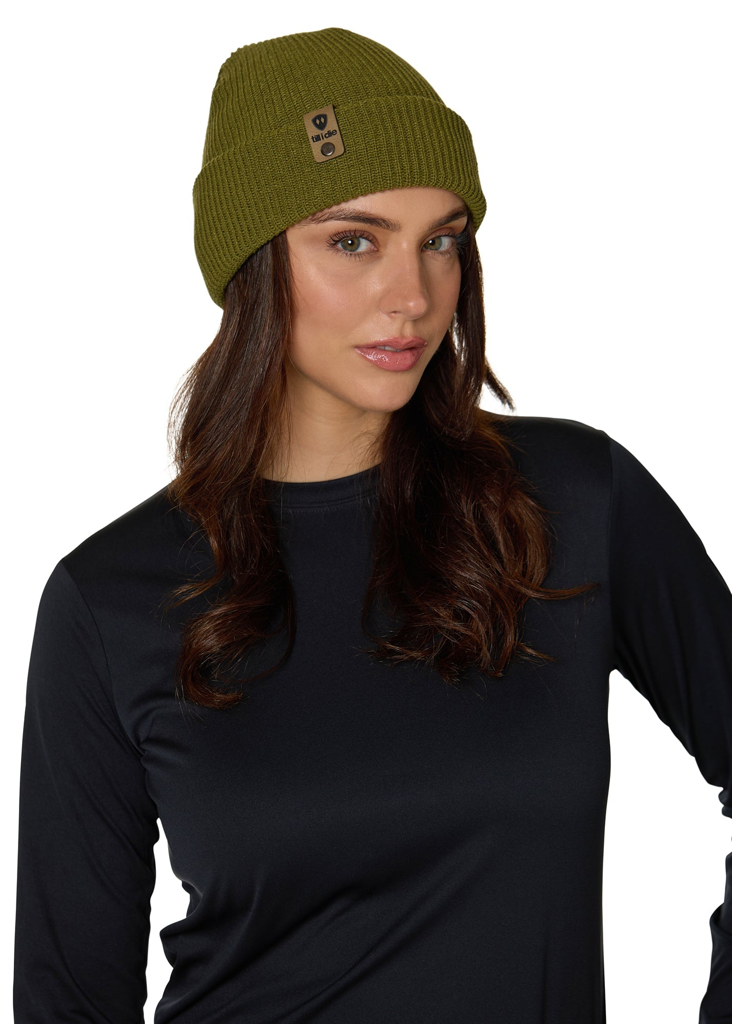 Female model wearing the Till I Die Leather Tab Knit Beanie in military green, showcasing the cozy fit and branded leather detail on the cuff