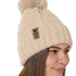side view of a female model wearing a vintage white knit pom beanie featuring a matching pom pom, cuff and leather till i die logo tab with a nickel fastener.
