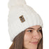 side view of a female model wearing a white knit pom beanie featuring a matching pom pom, cuff and leather till i die logo tab with a nickel fastener.