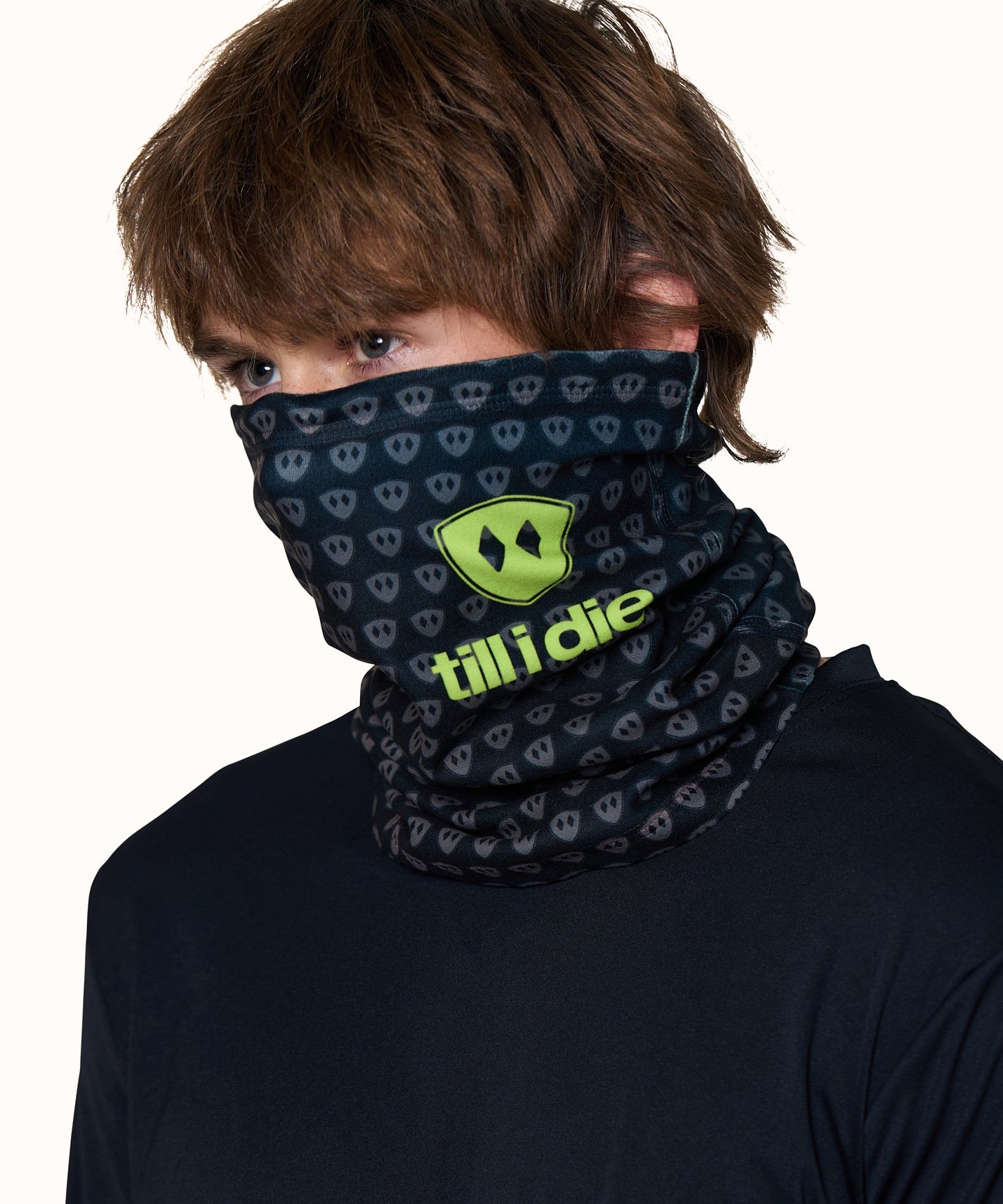 Male model wearing the Till I Die Logo Neck Gaiter in Lime, with the gaiter pulled up to cover his nose and neck.