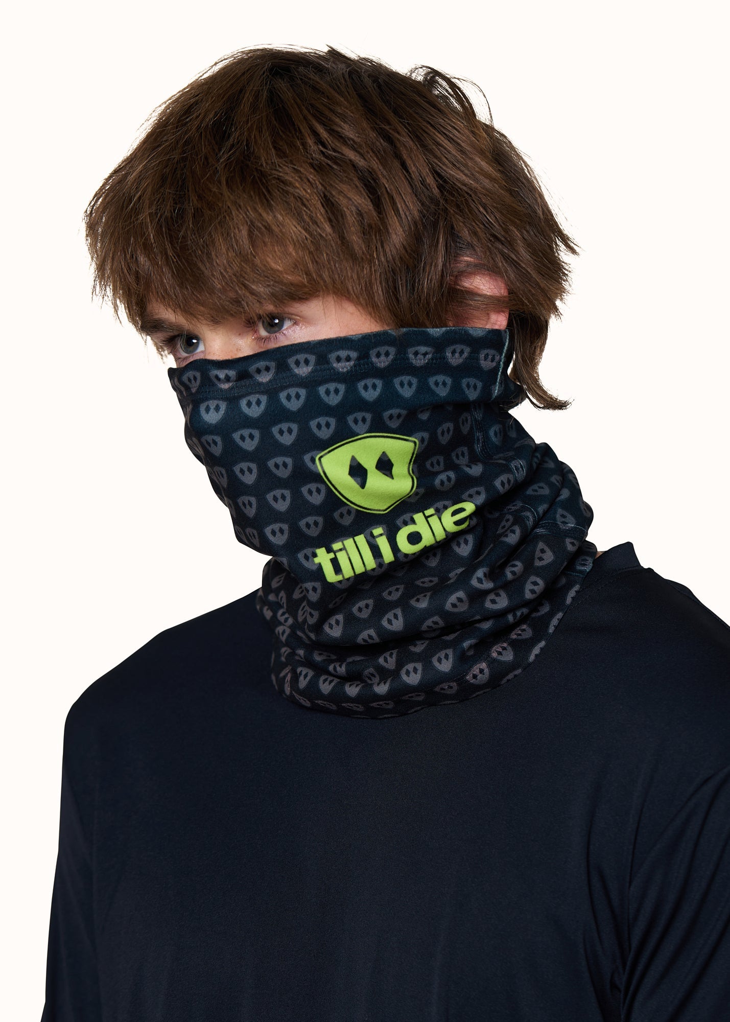 Male model wearing the Till I Die Logo Neck Gaiter in Lime, with the gaiter pulled up to cover his nose and neck.