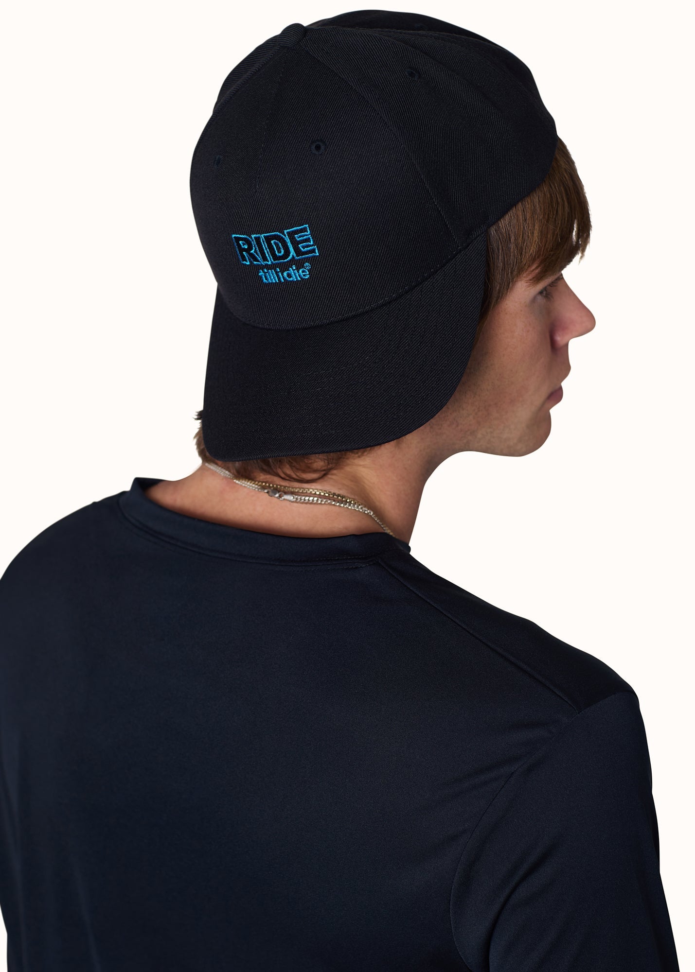 Male model wearing Ride Till I Die hat backwards with logo visible