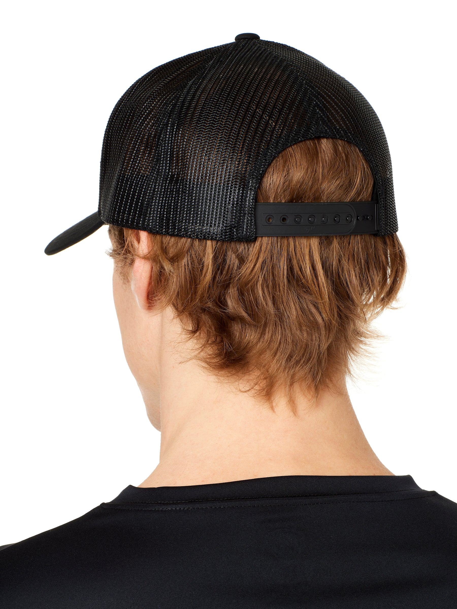 back view of a male model wearing a black classic trucker hat showing the mesh back panels and matching black snapback closure