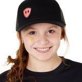 Front view of a youth wearing a black classic trucker hat with a pink embroidered double diamond shield on the bottom right panel