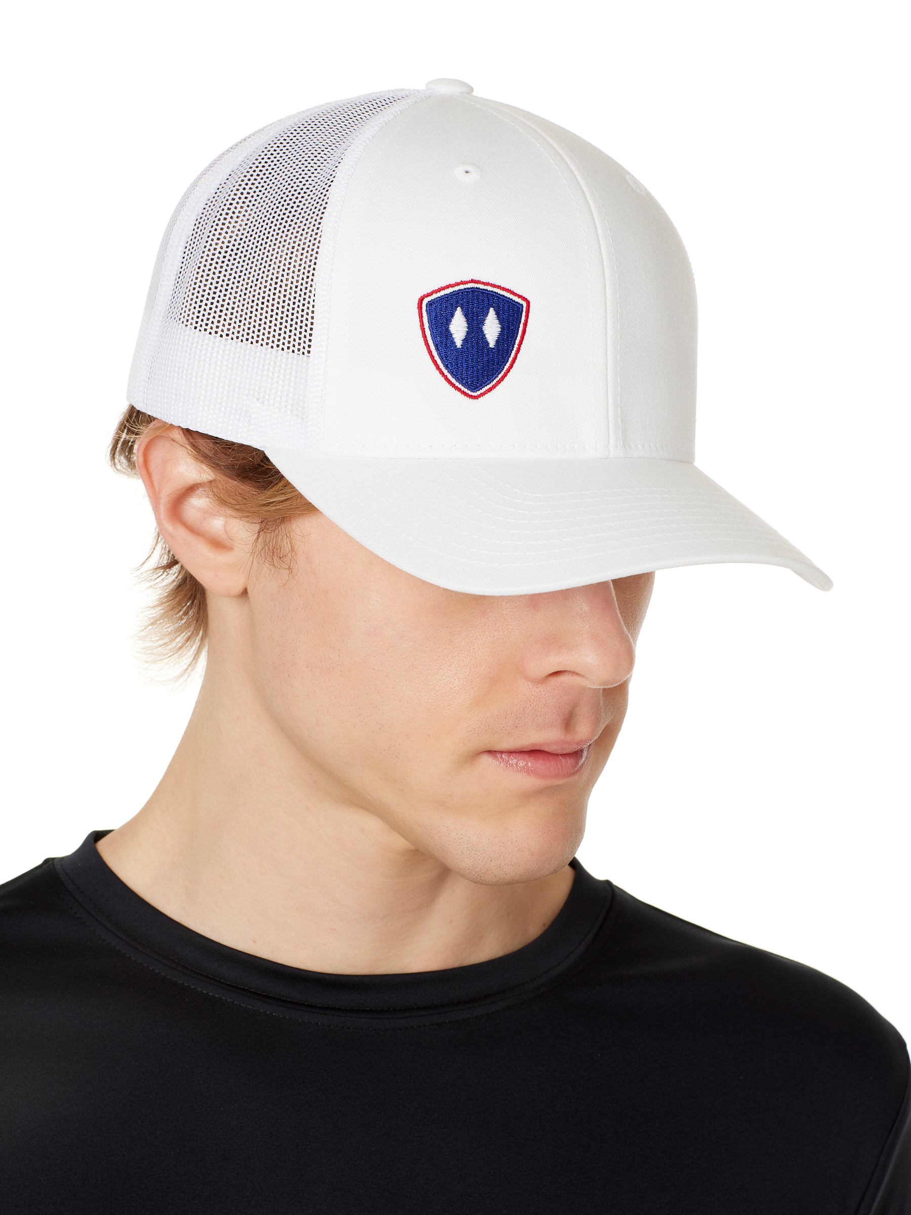 Front view of a male wearing a white classic trucker hat with a blue and red embroidered double diamond shield on the bottom right panel