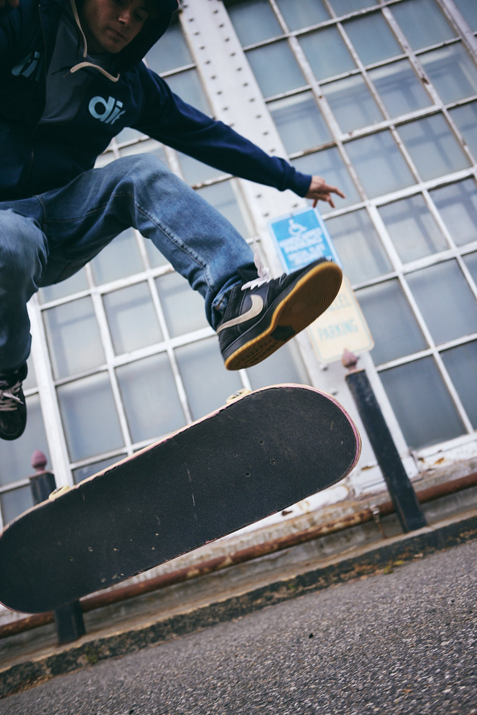 Person skateboarding in front of a building with large windows