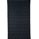 Overhead flat lay image of the back side of a black neck gaiter featuring a repeating dark gray diamond-shield pattern. The gaiter is placed on a white background.