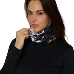Female model wearing the Skeleton Neck Gaiter, shown covering her neck as she holds it up toward her face.