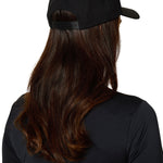 Back view of female model wearing Ski Till I Die black snapback hat with long hair and athletic top