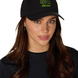 Female model wearing black Ski Till I Die snapback hat with neon green embroidery and curved brim