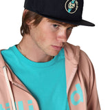 Model wearing a black surf hat with a Till I Die logo zip up hoodie in Rose with a Tahiti Blue shirt.