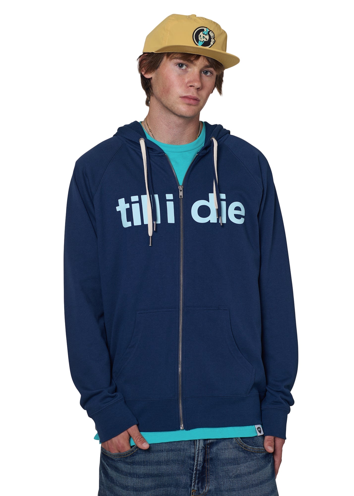 Model wearing a indigo blue zip up hoodie with Till I Die logo, Marigold Surf Cap, and Tahiti Blue shirt on a white background