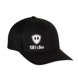 Front view of a black classic trucker hat, featuring a white embroidered Till I Die logo with double black diamonds and a white shield on the lower right front panel on a white background.