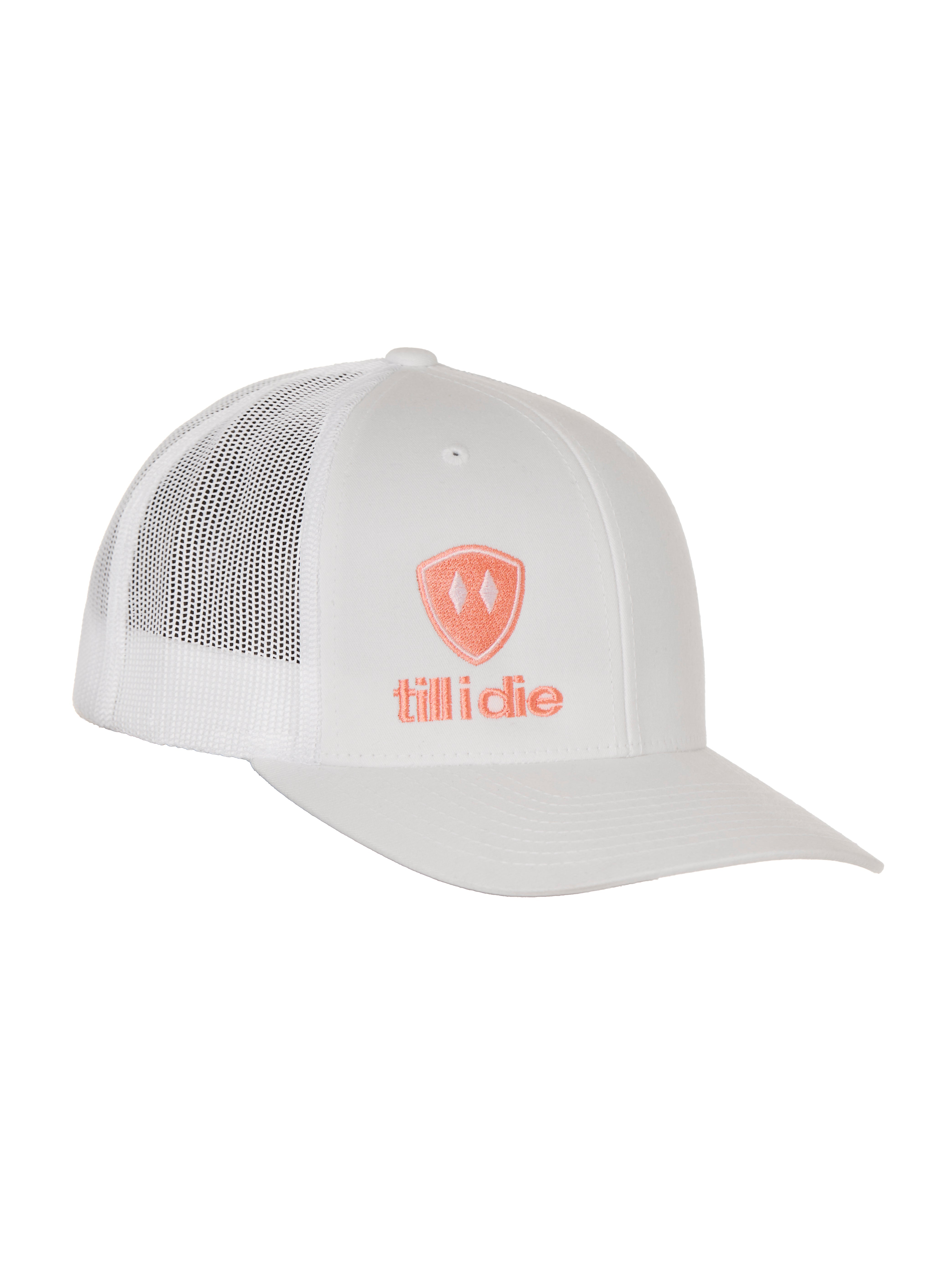 Front view of a white classic trucker hat, featuring a coral embroidered Till I Die logo with double white diamonds and a coral shield on the lower right front panel on a white background.