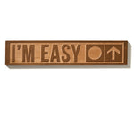 The “I’m Easy” ski trail sign shown on a white background, featuring natural cherry wood with visible grain. The design includes a circle and an upward-pointing arrow.