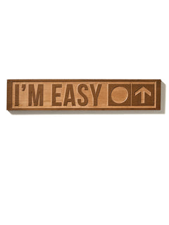 The “I’m Easy” ski trail sign shown on a white background, featuring natural cherry wood with visible grain. The design includes a circle and an upward-pointing arrow.