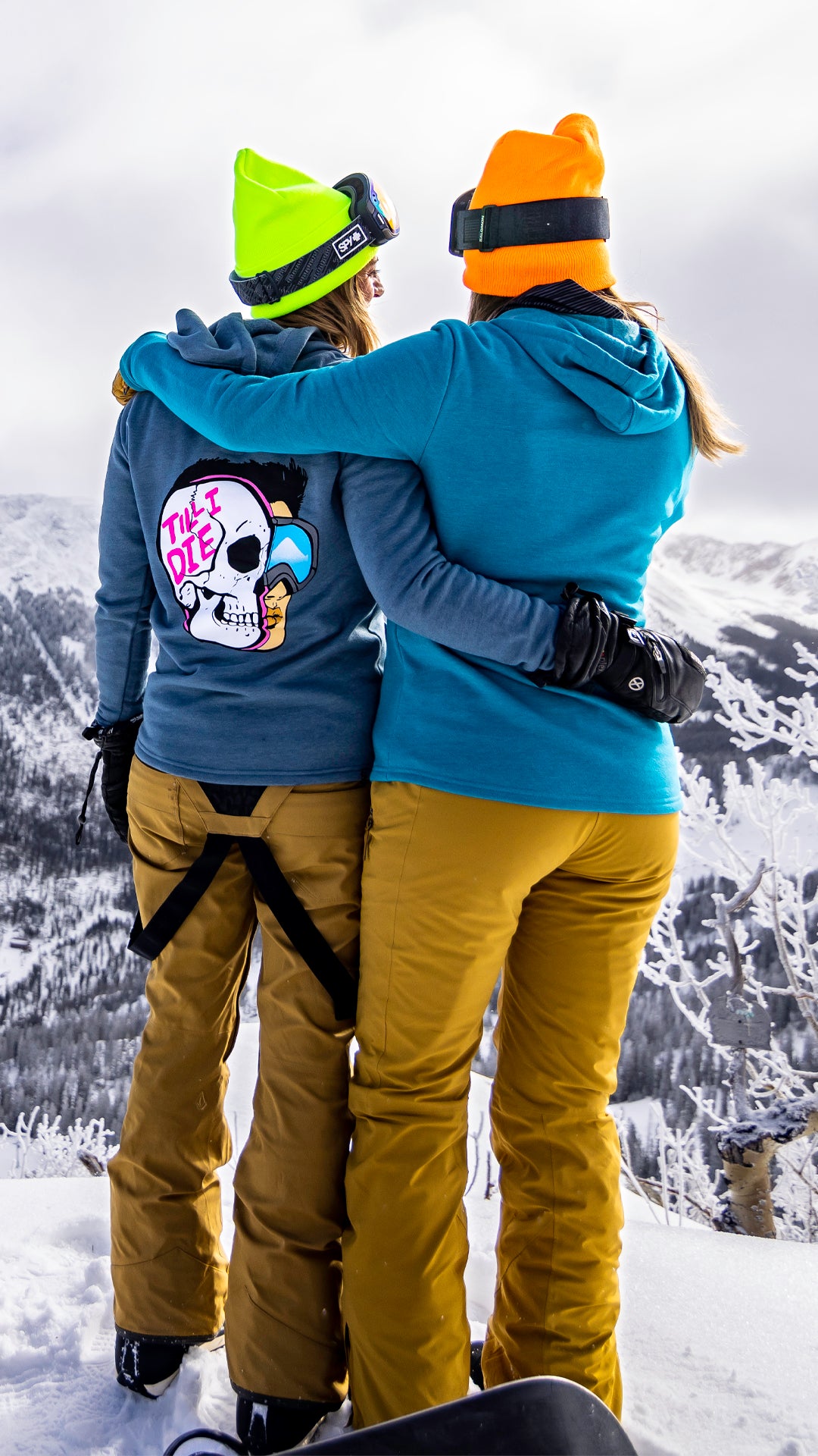 Two girls standing on a mountain wearing till I die hoodies